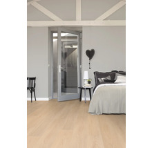 Slaapkamer met bed, nachtkastje, stoel en deur met glazen ruit