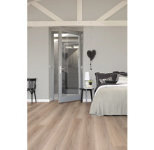 Slaapkamer met bed, nachtkastje, stoel, deur en lichte houten vloer