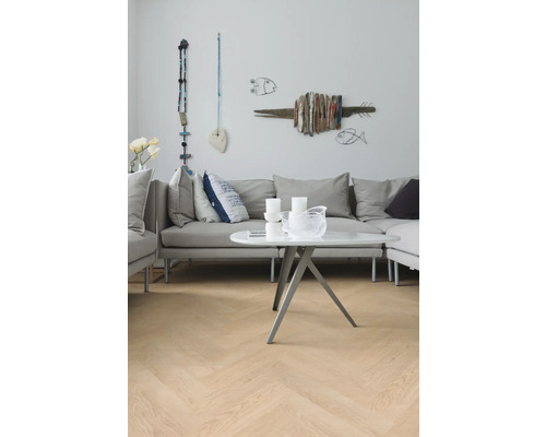 Woonkamer met grijze bank, witte tafel en visdecoratie aan de muur