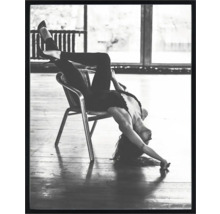 Zwart-witfoto van een vrouw die ondersteboven op een stoel zit