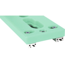 Close-up van een mintgroene klimwandgreep met bevestigingsschroeven