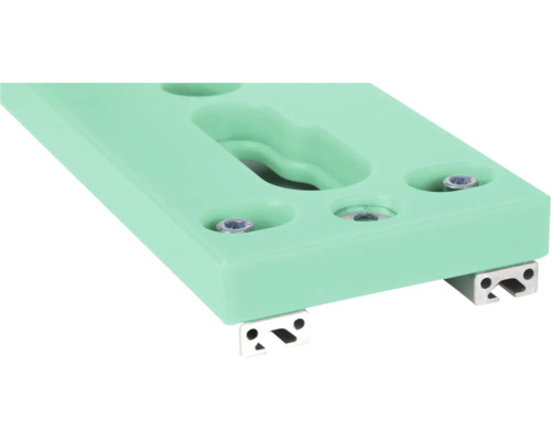 Close-up van een mintgroene klimwandgreep met bevestigingsschroeven