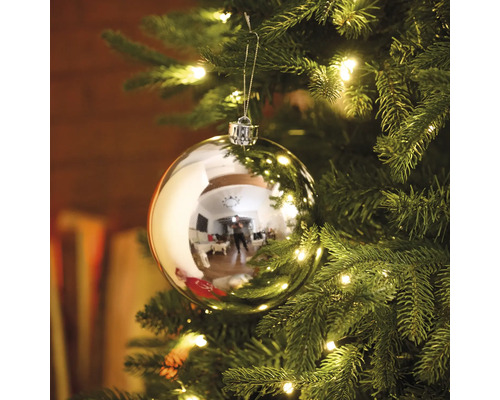 Kerstbal aan een kerstboom met verlichting