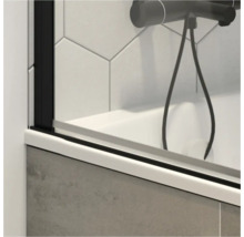 Detailopname van een badwand met zwarte fittingen en een douchekraan.