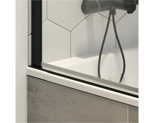 Detailopname van een badwand met zwarte fittingen en een douchekraan.