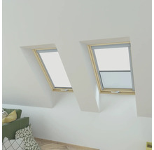 Twee dakramen met openstaand raam en rolgordijn in een zolderkamer