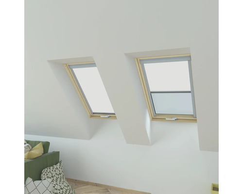 Twee dakramen met openstaand raam en rolgordijn in een zolderkamer