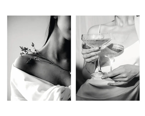 Zwart-witafbeelding van een vrouw met een bloem op haar schouder en een vrouw die een glas vasthoudt