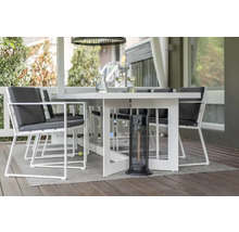 Tuinscene met eettafel, stoelen en terrasverwarmer voor een gezellige buitensfeer