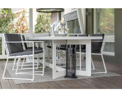 Tuinscene met eettafel, stoelen en terrasverwarmer voor een gezellige buitensfeer