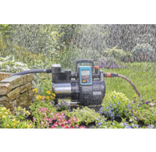 Tuinpomp in gebruik voor het besproeien van een tuin