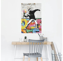 Wandschildering met Banksy graffiti motief boven een bureau