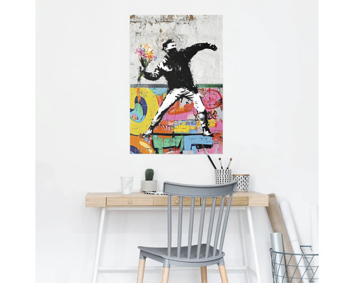 Wandschildering met Banksy graffiti motief boven een bureau