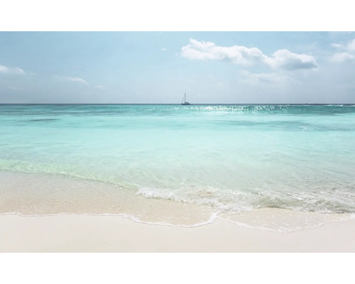 Een helder zandstrand met turquoise zee en een zeilboot aan de horizon