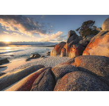 Zandstrand met rotsen en uitzicht op zee bij zonsopgang