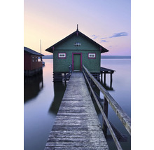 Houten loopbrug leidt naar een gebouw op het water.