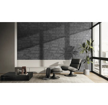 Moderne woonkamer met grijze bakstenen muur, fauteuil en kamerplant