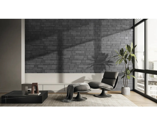 Moderne woonkamer met grijze bakstenen muur, fauteuil en kamerplant