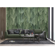 Woonkamer met bank en wandbehang met bladerenmotief