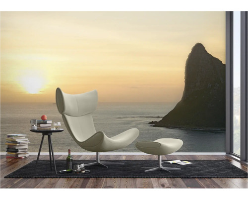 Woonkamer met fauteuil, voetenbank en fotobehang met zeethema