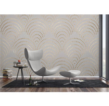 Woonkamer met fauteuil en muur met behang met gouden patroon