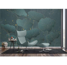 Decoratief interieur met behang met bladmotief, fauteuil en bijzettafel.