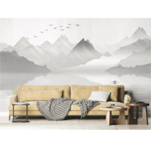 Woonkamer met fotobehang van een berglandschap, bank en bijzettafels