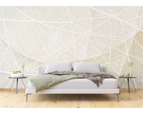 Slaapkamer met wit beddengoed en fotobehang met bladmotief