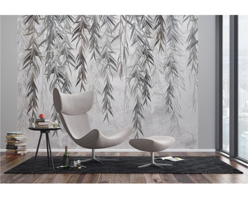 Decoratieve wand met een bladerenmotief achter een fauteuil en een bijzettafel