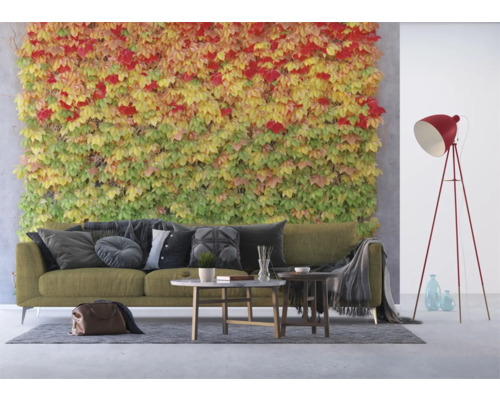 Woonkamer met bank, salontafels, vloerlamp en wandbegroening.