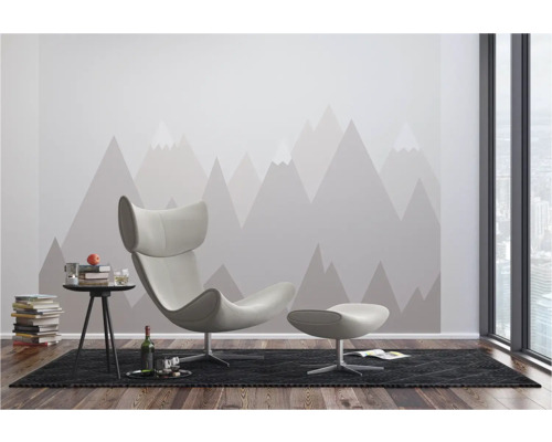 Moderne woonkamer met fauteuil, voetenbank, bijzettafel en behang met bergmotief.