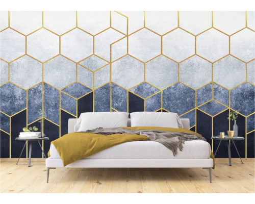 Een slaapkamer met een behang met gouden geometrische vormen achter een bed