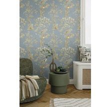 Decoratieve woonkamer met bloemenbehang, fauteuil en bijzettafel.