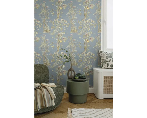 Decoratieve woonkamer met bloemenbehang, fauteuil en bijzettafel.