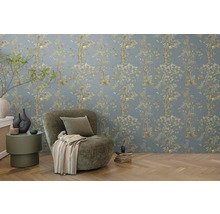 Gedecoreerde kamer met bloemenbehang, fauteuil en bijzettafel.