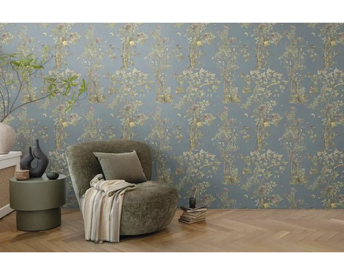 Gedecoreerde kamer met bloemenbehang, fauteuil en bijzettafel.