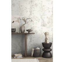 Decoratieve kamer met bloemenbehang, houten tafel, kunstwerken en decoratieve objecten.