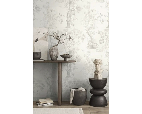 Decoratieve kamer met bloemenbehang, houten tafel, kunstwerken en decoratieve objecten.