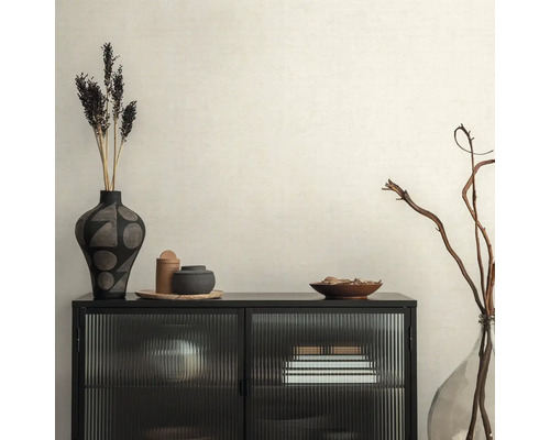 Decoratief interieur met zwarte kast, vazen en droogbloemen op beige behang.