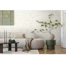 Woonkamer met bloemenbehang, bank, tafel en decoraties voor een gezellige sfeer.