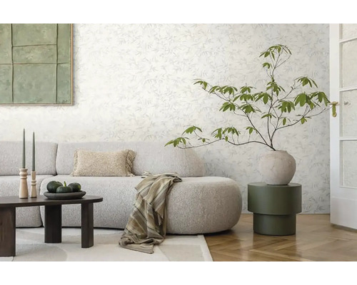Woonkamer met bloemenbehang, bank, tafel en decoraties voor een gezellige sfeer.