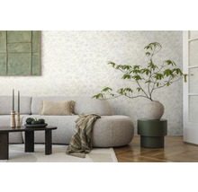 Woonkamer met patroonbehang, bank, tafel en decoraties voor een stijlvolle sfeer.