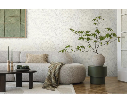 Woonkamer met patroonbehang, bank, tafel en decoraties voor een stijlvolle sfeer.