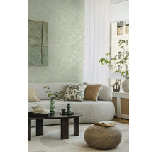 Woonkamer met bank, salontafel, kruk, kussens en wanddecoratie