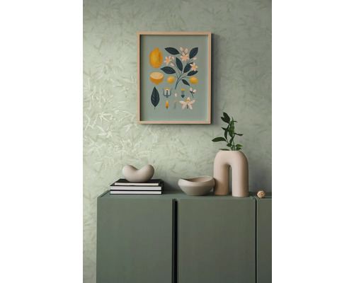 Decoratieve scène met een dressoir, erop een decoratieve schaal, boeken en een vaas, aan de muur een foto met citroenmotieven
