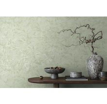 Decoratieve kamer met behang met patroon en tafel met diverse decoratieve elementen.