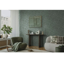 Woonkamer met groen bladerbehang, fauteuil en bank