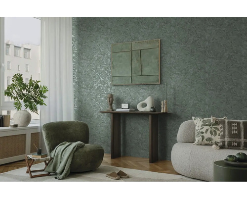 Woonkamer met groen bladerbehang, fauteuil en bank
