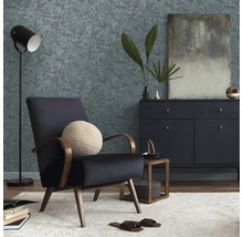 Woonkamer met fauteuil, commode, staande lamp en behang met motief