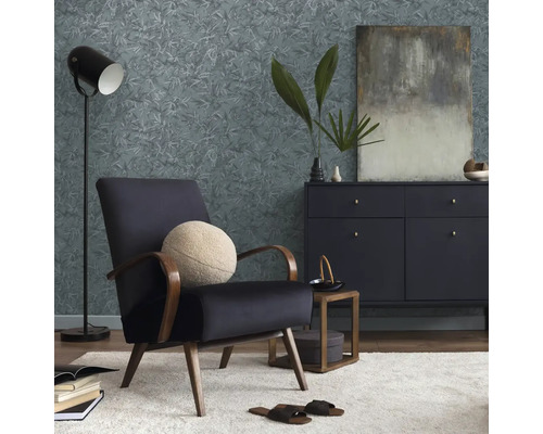 Woonkamer met fauteuil, commode, staande lamp en behang met motief